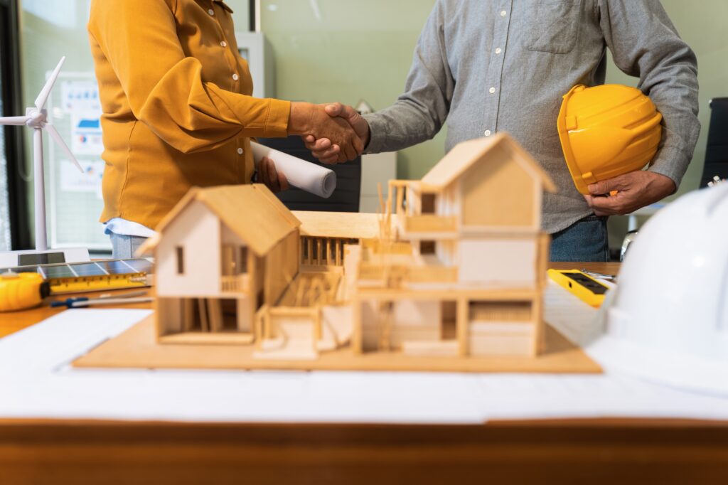architects and engineers shake hands while working for teamwork.